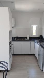 a white kitchen with white cabinets and a window at Estudio Urbano in Santa Rosa