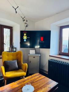 Zimmer mit einem Tisch, einem gelben Stuhl, einem Tisch und einem Stuhl in der Unterkunft Star Gazers Cottage in Martínkovice