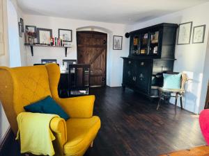 ein Wohnzimmer mit einem gelben Sofa und einem Sessel in der Unterkunft Star Gazers Cottage in Martínkovice