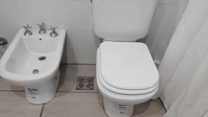 a bathroom with a white toilet and a sink at Estudio Urbano in Santa Rosa