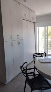 a kitchen with white cabinets and a table and chairs at Estudio Urbano in Santa Rosa