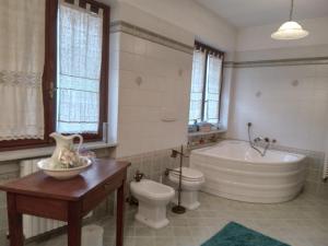 a bathroom with a tub and a toilet and a sink at Bed and Breakfast di Nonna Piera in Casalborgone
