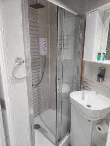 a bathroom with a shower and a toilet and a sink at Blue Moon Ensuite in Netherton +4 photos