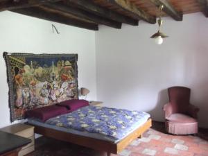 a bedroom with a bed and a painting on the wall at Gite Tauzia in Brassempouy