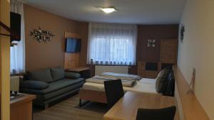 un salon avec un canapé et une table dans l'établissement Pension am Schlossberg, à Reichenberg