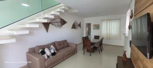 ein Wohnzimmer mit Couch und ein Esszimmer in der Unterkunft Casa 3 quartos 2 suítes na praia a 2km da Atalaia in Aracaju