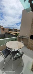 ein Tisch und zwei Stühle auf einem Balkon in der Unterkunft Casa 3 quartos 2 suítes na praia a 2km da Atalaia in Aracaju