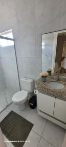 ein Badezimmer mit Toilette, Waschbecken und Spiegel in der Unterkunft Casa 3 quartos 2 suítes na praia a 2km da Atalaia in Aracaju + 17 Fotos