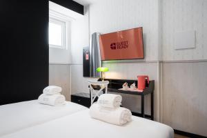 a hotel room with two beds and a tv at The Twenties by GuestReady in Lisbon