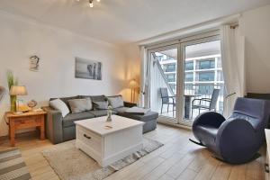 een woonkamer met een bank en een tafel bij Seebrücke Seebrücke Appartement 22 in Scharbeutz