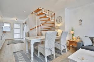 een woonkamer met een trap en een tafel en stoelen bij Seebrücke Seebrücke Appartement 22 in Scharbeutz +15 foto's