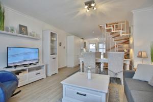 een woonkamer met een bank, een tv en een tafel bij Seebrücke Seebrücke Appartement 22 in Scharbeutz