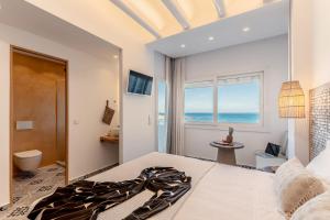 a bedroom with a bed and a view of the ocean at Flèria Seaview Suites in Naxos Chora