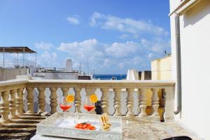 a balcony with a table and two glasses of wine at Palazzo Senape De Pace in Gallipoli