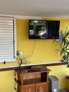 einen TV an einer gelben Wand in einem Zimmer in der Unterkunft Porta Marina Ascea Marina Velia in Marina di Ascea