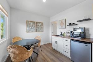 eine Küche mit einem Tisch, Stühlen und einer Mikrowelle in der Unterkunft South O Bungalow 11 - Luxury King Suite + Patio in Oceanside + 19 Fotos