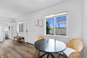 ein Esszimmer mit Tisch und Stühlen und einem Fenster in der Unterkunft South O Bungalow 11 - Luxury King Suite + Patio in Oceanside