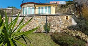 a stone wall with a house on top of it at Mare e Relax - Il Villino ai Tre Ponti - Monolocale in Sanremo