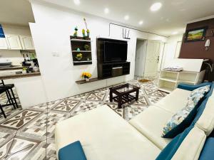 a living room with a couch and a tv at Confort Home Apartamentos Vacacionales in Baños