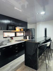 a kitchen with black cabinets and a black counter top at D Calles Place LA PUNTA in La Libertad +14 photos
