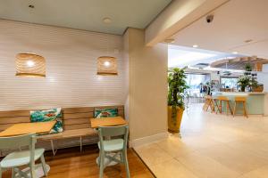 リオデジャネイロにあるB&B HOTEL Rio Copacabana Forteの木製のベンチ、テーブル、椅子が備わるレストラン