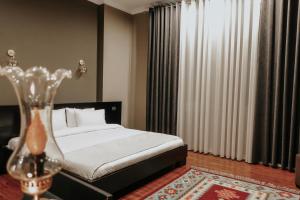 a bedroom with a bed and a vase on a table at Monun Boutique Hotel in Tirana +26 photos