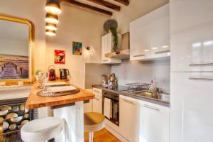 une cuisine avec des armoires blanches et un comptoir dans l'établissement La Casa Bella — Parking privé & vue sur l'abbaye, à Caen