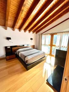 a bedroom with a bed in a room with wooden ceilings at Chalet Huerta de Cañamal - Llanes in Llanes