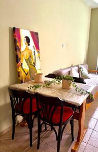 a dining room table with chairs and a painting on the wall at Alpha apartment Η2 in Serres +5 photos