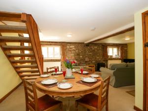 ein Esszimmer mit einem Holztisch und Stühlen in der Unterkunft Anvil Cottage in Blakeney