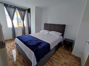 a bedroom with a large bed with a blue blanket at Apartahotel JDK in Armenia