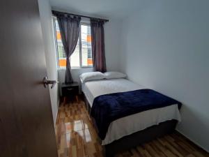a small bedroom with a bed and a window at Apartahotel JDK in Armenia