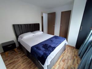 a bedroom with a large bed with a blue blanket at Apartahotel JDK in Armenia