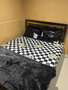 a bed with a black and white checkered bedspread at Stay Inn in Pattaya Central