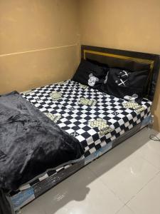a bed with a black and white checkered blanket at Stay Inn in Pattaya Central +1 photo