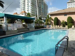 una gran piscina con sillas y un edificio en PlayaBlanco Suites, en Fort Lauderdale