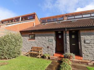 a house with a wooden bench in the yard at Waters Edge in Alnwick