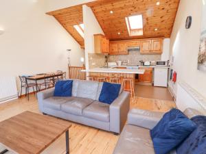 a living room with a couch and a kitchen at Waters Edge in Alnwick