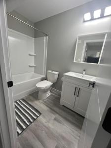 a bathroom with a toilet and a sink and a mirror at Cutee Home Prairie Pointe in Winnipeg +14 photos