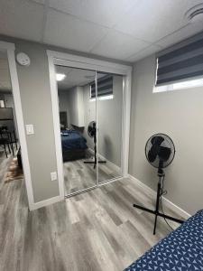 a bedroom with a mirror and a room with a bed at Cutee Home Prairie Pointe in Winnipeg