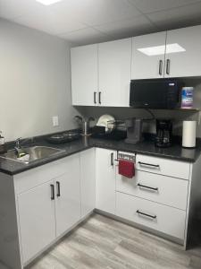 a kitchen with white cabinets and a sink at Cutee Home Prairie Pointe in Winnipeg
