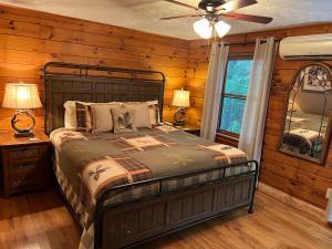 a bedroom with a bed and a ceiling fan at Log Cabin in Bailey Camp