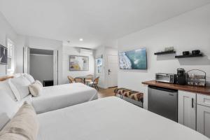 ein Hotelzimmer mit zwei Betten und einer Küche in der Unterkunft South O Bungalow 7 - Premium Double Studio + Patio in Oceanside