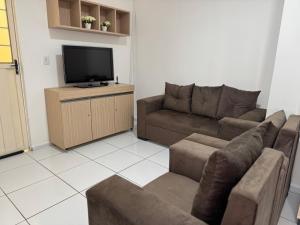 a living room with a couch and a flat screen tv at Meu Flat Temporada in Petrolina