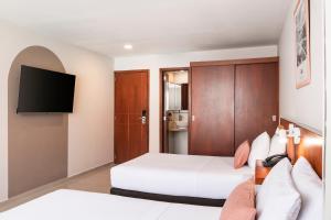 a hotel room with two beds and a tv at Hotel MS Chipichape in Cali