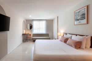 a white bedroom with a large bed and a couch at Hotel MS Chipichape in Cali +25 photos