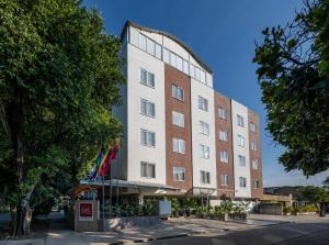 a tall building with flags in front of it at Hotel MS Chipichape in Cali
