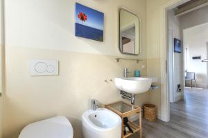 a bathroom with a sink and a toilet and a mirror at Il Quartiere apt Montecristo in Pomonte