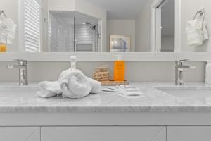 a bathroom counter with two sinks and a towel and a bottle of soap at Blue Ibis in Sanibel +73 photos