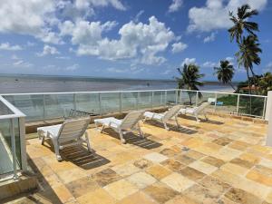 a patio with chairs and a view of the beach at Casa Beira Mar com Piscina Maragogi - Amar & Mar in Maragogi